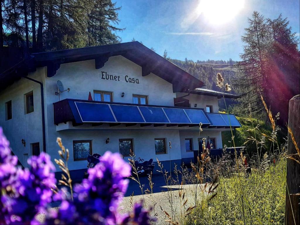 海利根布卢特Ebner Casa的一座有蓝色屋顶的建筑,背面有太阳