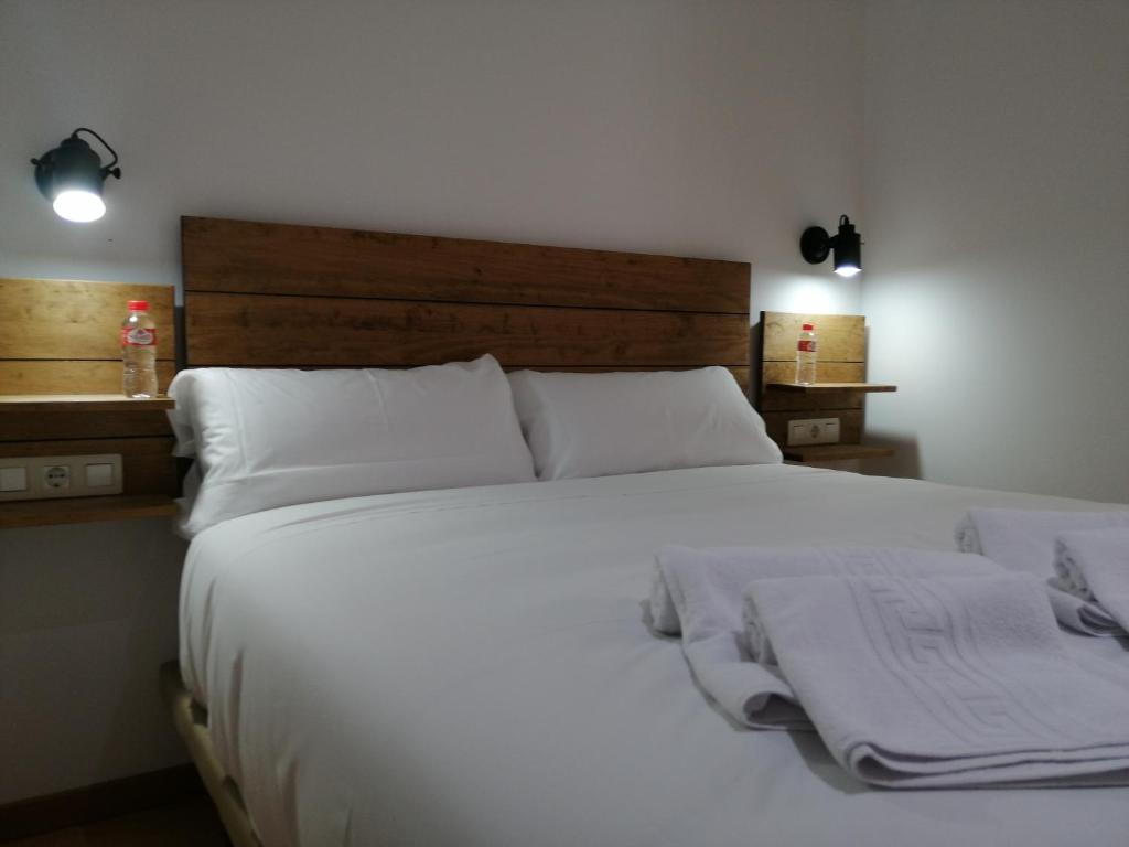 布尔戈斯Hostal Cuéntame Evolución Auto Check in的卧室配有一张带白色床单和枕头的大床。