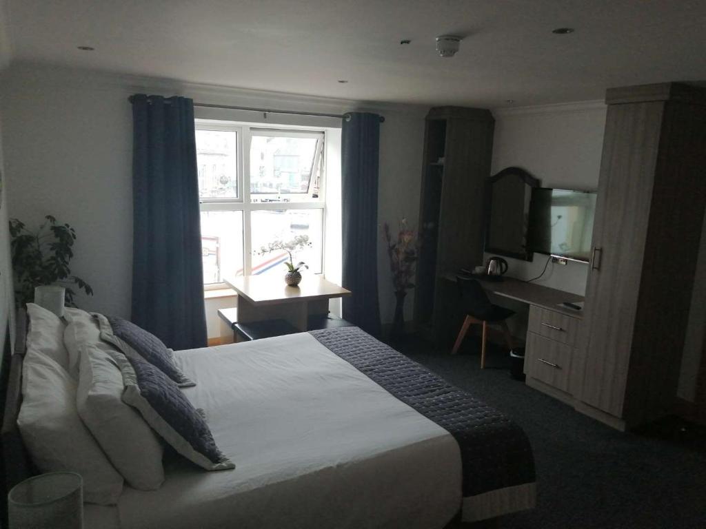 多尼戈尔Reveller Lodgings的一间卧室设有一张带电视和窗户的床。