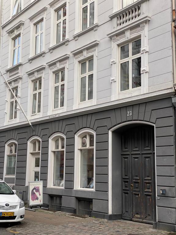 哥本哈根PSG 23 - Short Stay Apartments by Living Suites的一座有门的建筑,前面有一辆汽车