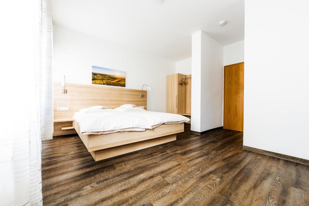 海尔布隆苏尔博思特酒店的卧室拥有白色的墙壁和木地板,配有一张床