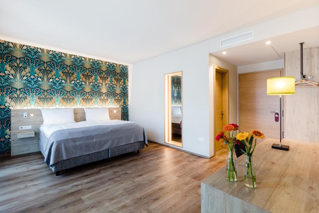 Beringen马萨酒店的一间卧室,配有一张床和花瓶