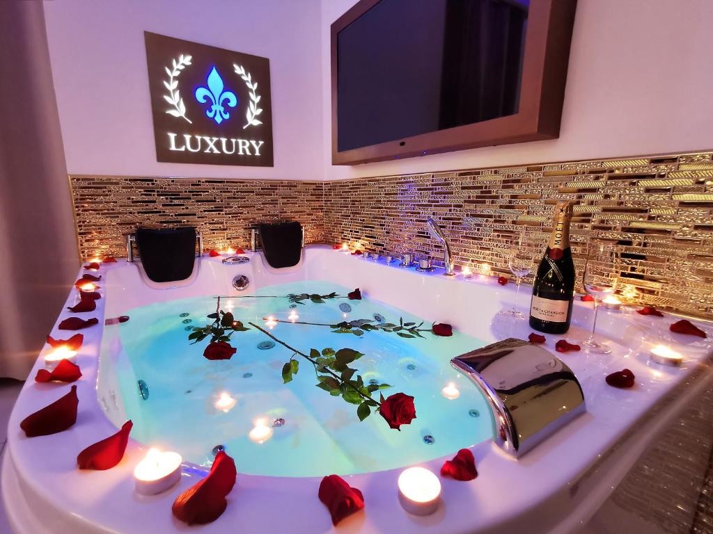 罗马Giglio Luxury Apartment - Chroma Italy的热水浴池(带蜡烛和一瓶葡萄酒)