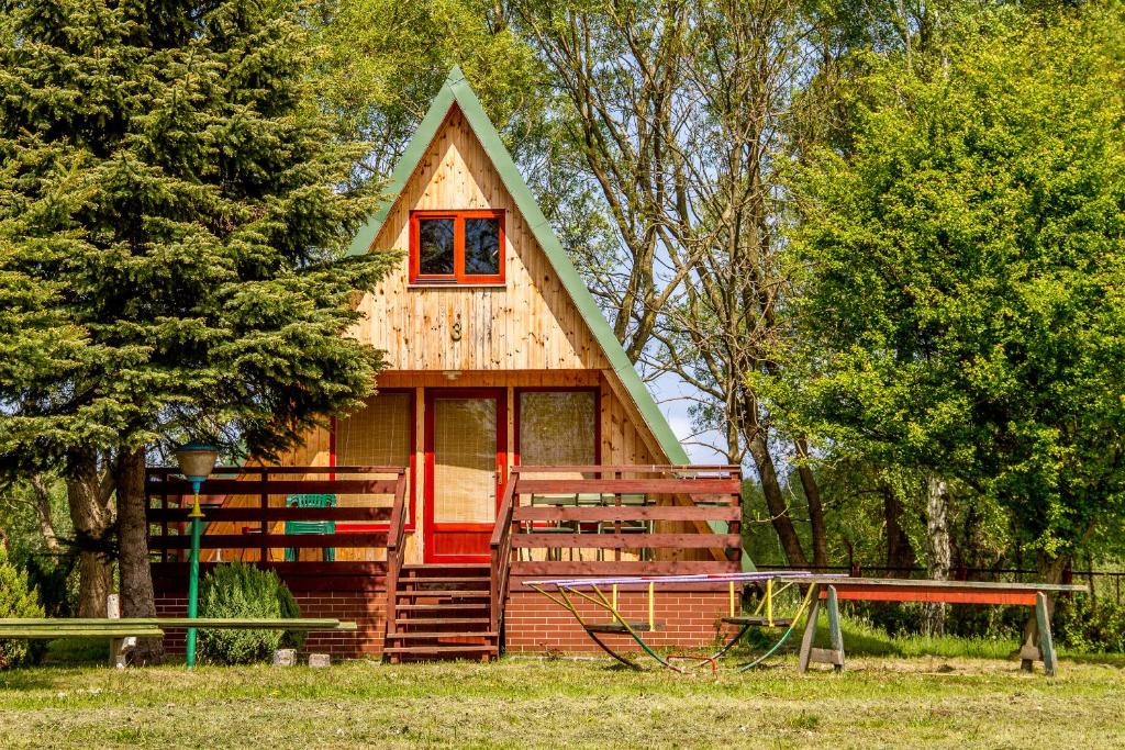 德兹维济诺The Rainbow - Domki Letniskowe的森林中一座带红色门的小房子