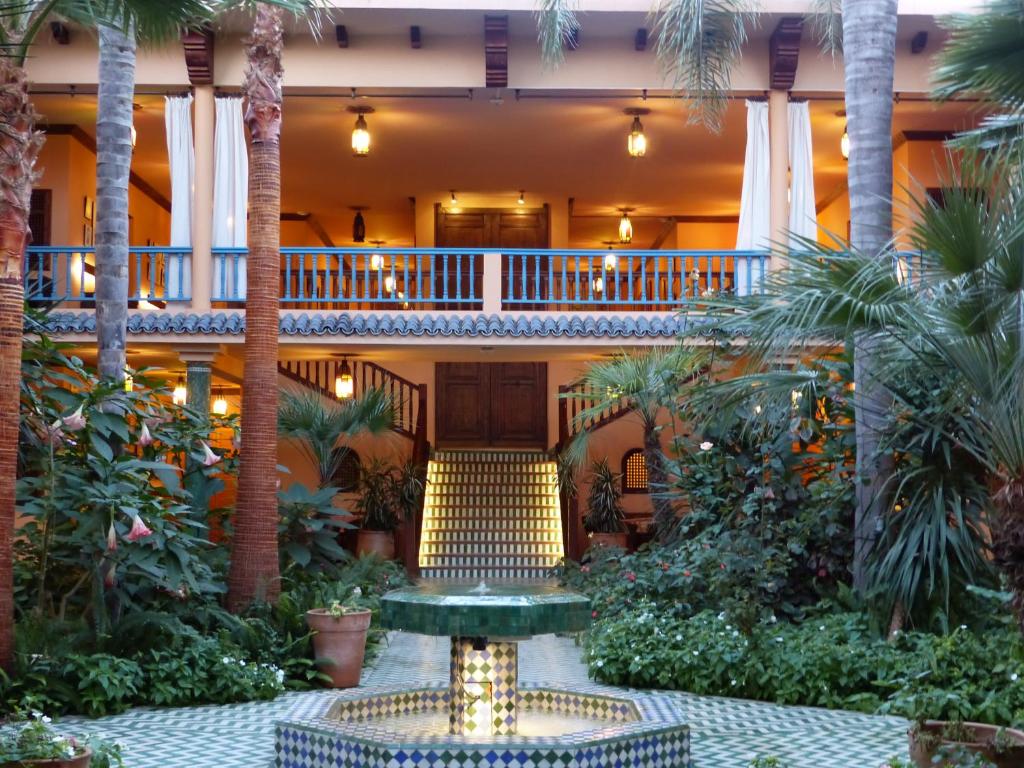 拉巴特拉威拉蔓特林酒店的棕榈树和喷泉酒店中庭