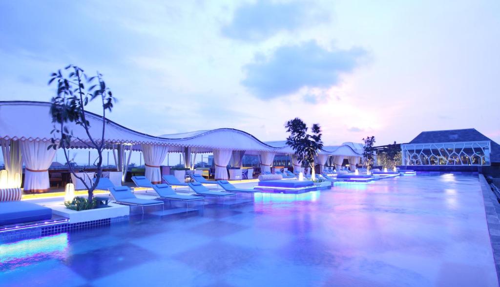 勒吉安塞米亚克巴厘岛TS套房酒店的一个带躺椅的游泳池,一个度假村