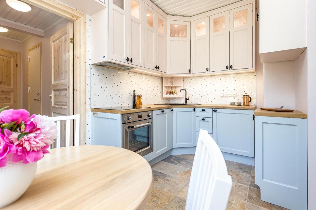 维尔扬迪Lakeview beach apartment in Viljandi的厨房配有白色橱柜和木桌