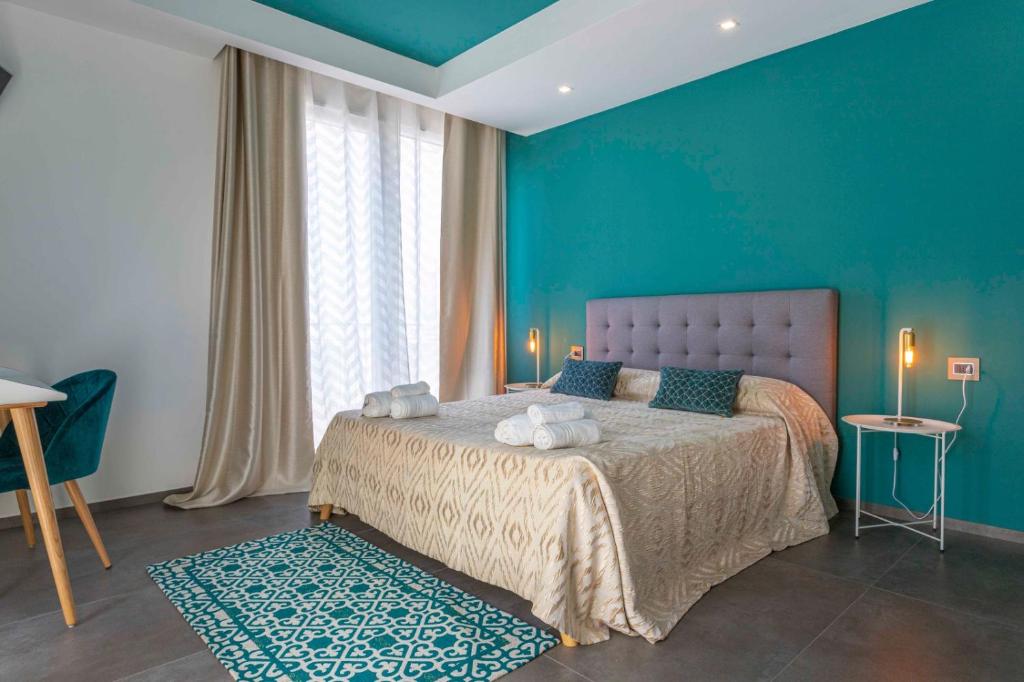 切萨雷奥港Albergo Piazza Risorgimento的一间卧室配有一张蓝色墙壁的床