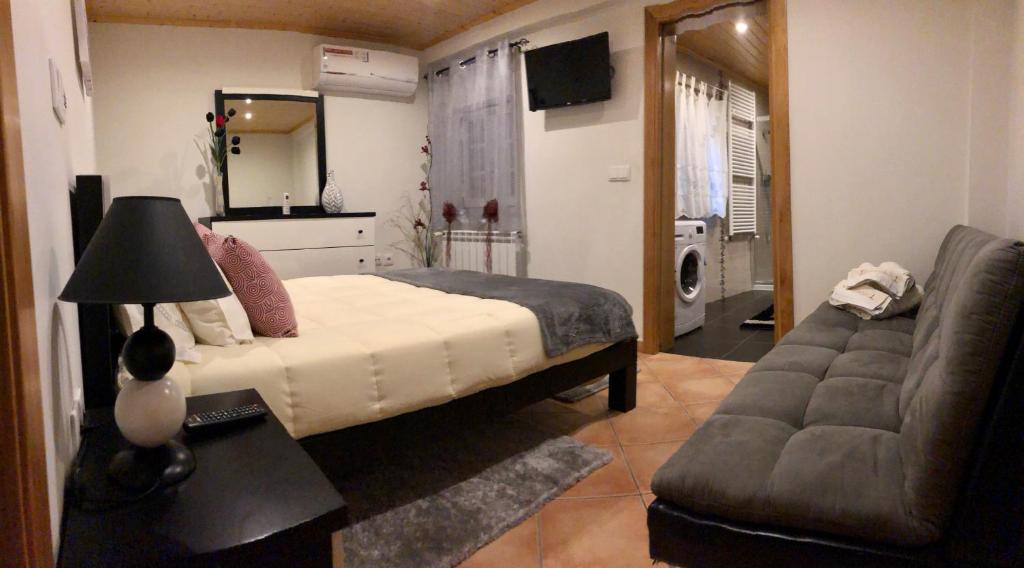 MeloAlojamento Pelourinho的一间卧室配有一张床、一张沙发和一面镜子