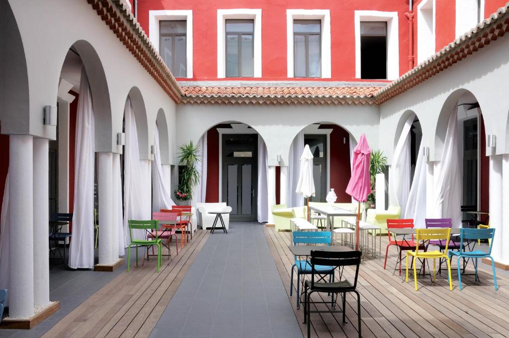 塞特港巴黎酒店的庭院里设有五颜六色的桌椅,大楼里