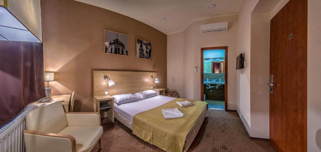 布达佩斯Budapest Citi Guesthouse - self check in的酒店客房配有一张床、一张桌子和一把椅子。