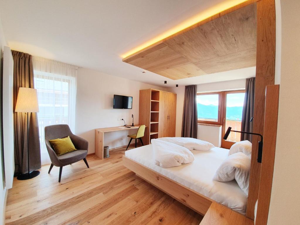 马兰扎Hotel Pfeiferhof的一间卧室配有一张床、一张桌子和一把椅子