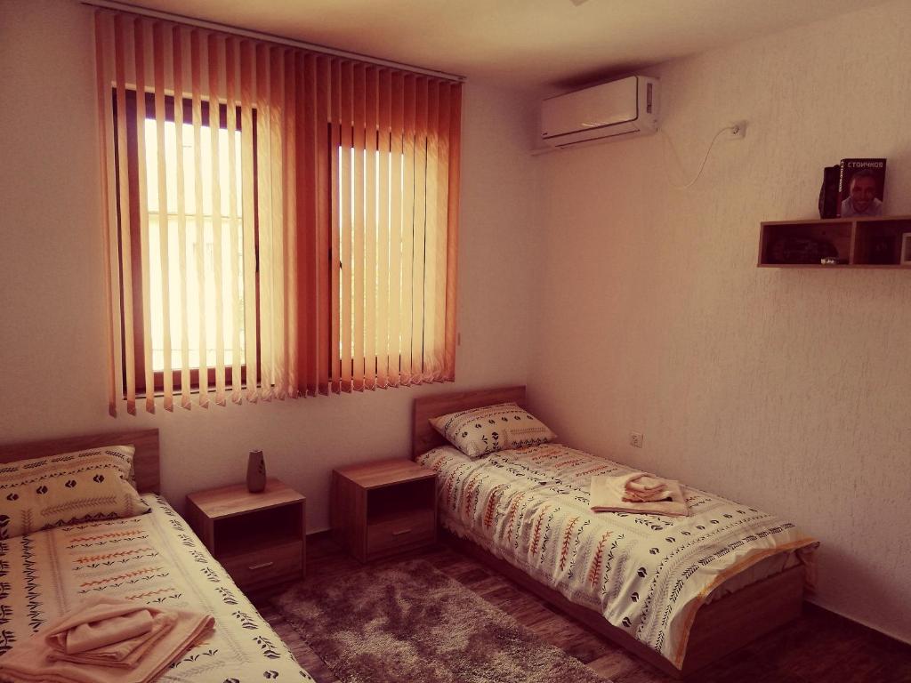 特里亚夫纳Petrov Apartment的一间卧室设有两张床和窗户。