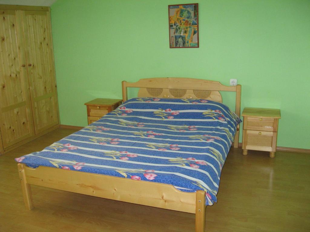 舒门Кристи的一间卧室配有一张带蓝色棉被的床和两张桌子