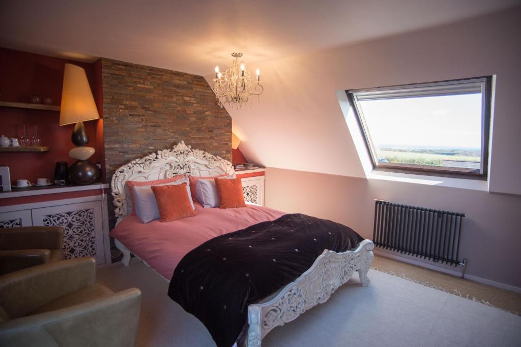 查希尔Birdsong Cottage Bed and Breakfast的一间卧室设有一张大床和窗户
