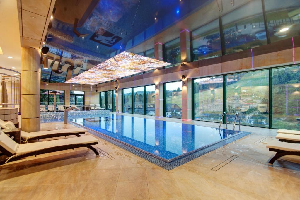 克雷尼察Hotel Pegaz的一座大型游泳池,位于一座带窗户的建筑内
