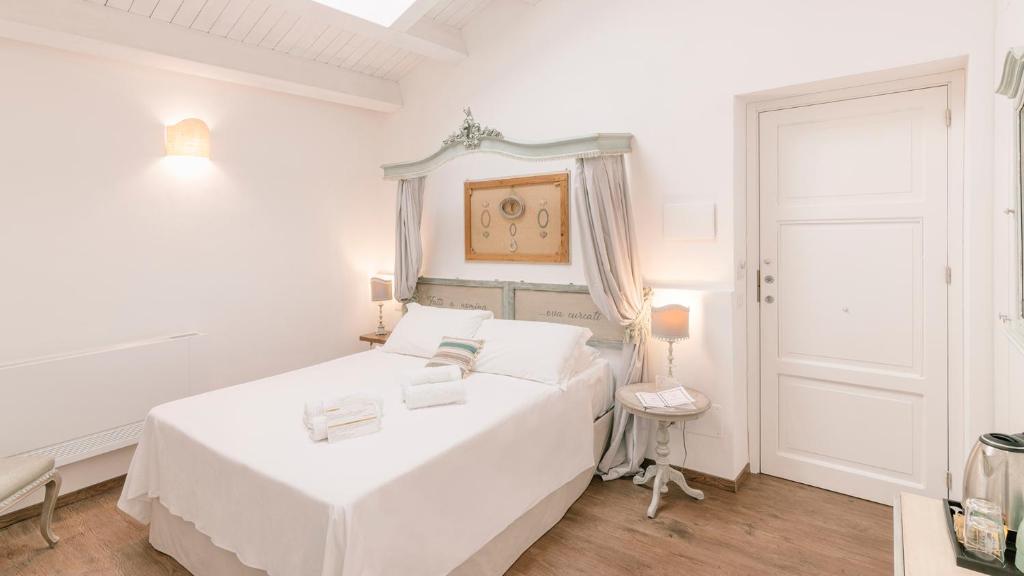 巴勒莫Addimora Boutique Suites的白色的卧室设有白色的床和门