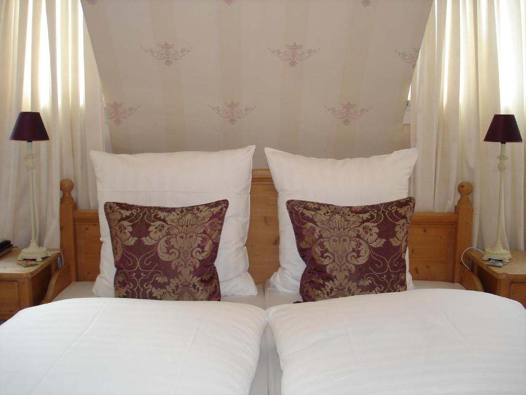 萨尔布吕肯贝利斯切沃尔夫萨尔布吕肯酒店的一间卧室配有两张带白色床单和枕头的床。