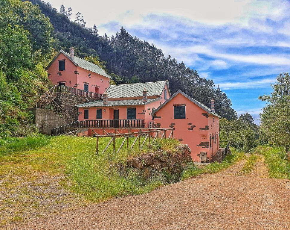 圣维森特Casinhas da Laurissilva的路边小山上的粉红色大房子