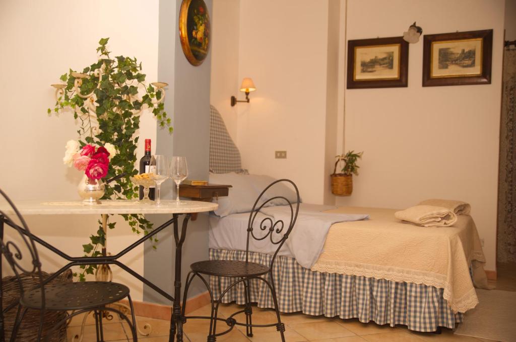 切法卢B&B del Giglio的配有一张床和一张桌子及椅子的房间