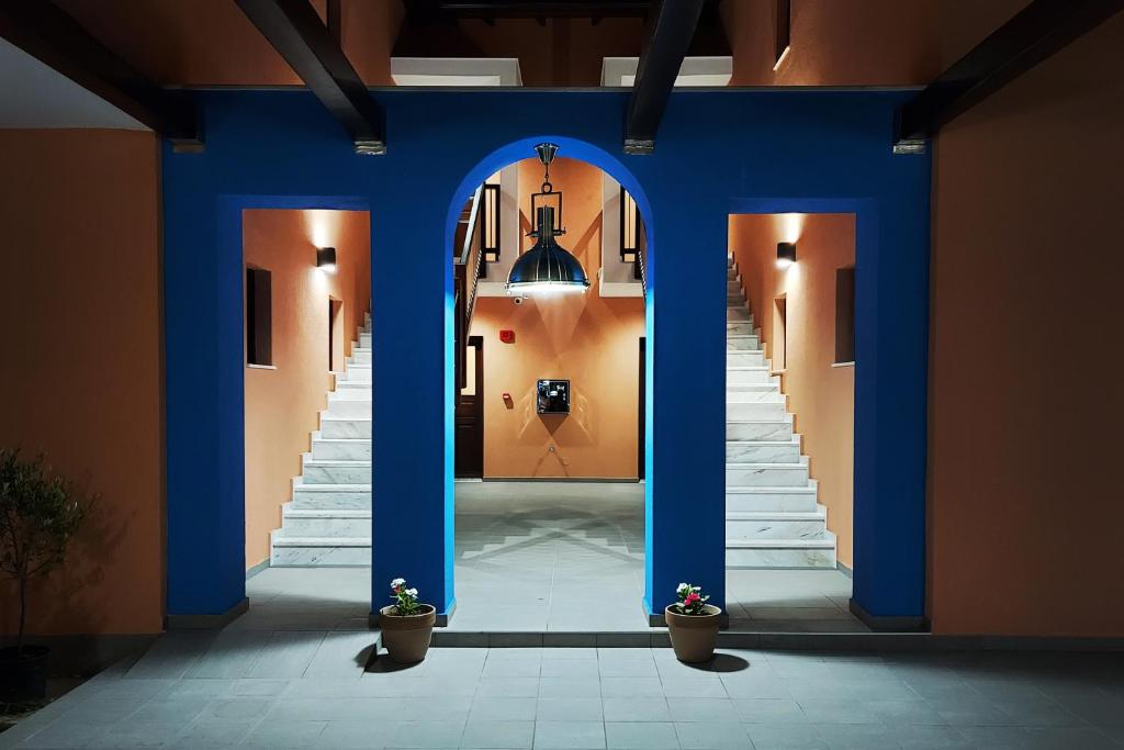 伊里斯斯Melia Villas的建筑里带蓝色柱子和楼梯的走廊