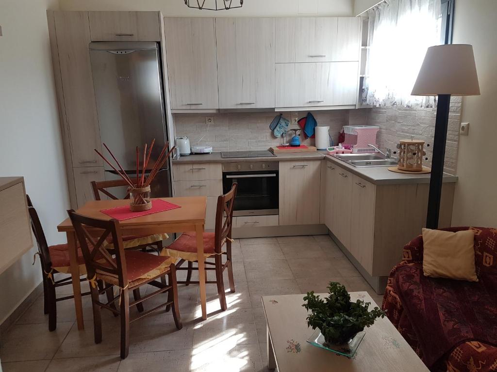 伊勒奥那斯Eleonas Farm House的一间带桌椅的厨房和一间带白色橱柜的厨房