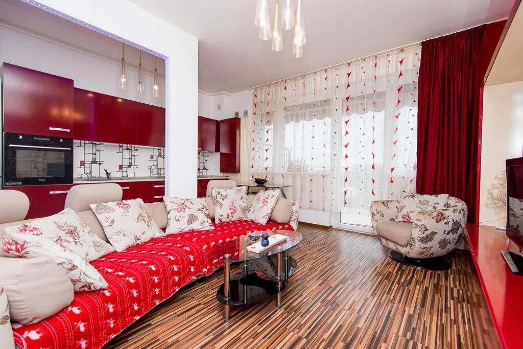 阿拉德Relaxing Spa Apartment的客厅配有红色的沙发和两把椅子