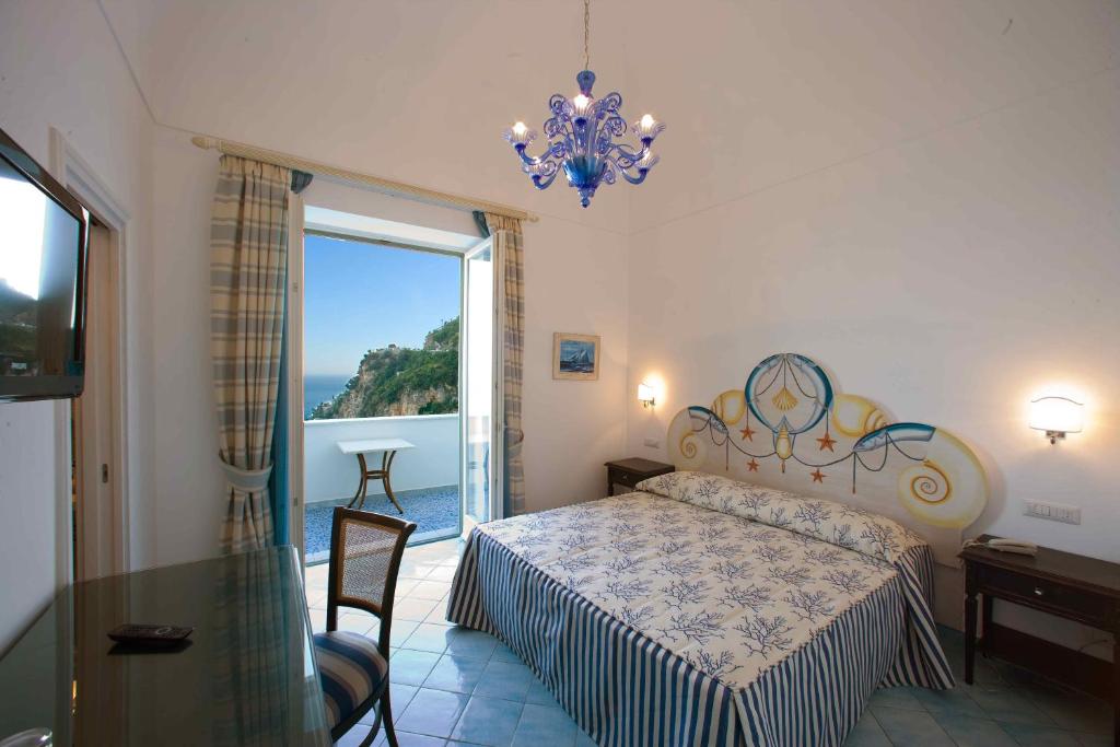 波西塔诺Palazzo Marzoli charme Resort - Small Luxury Hotel的一间卧室设有一张床和一个大窗户