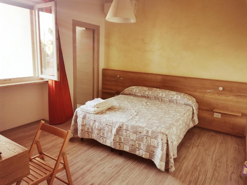 拉卡莱Via alessandria的卧室配有床、椅子和窗户。