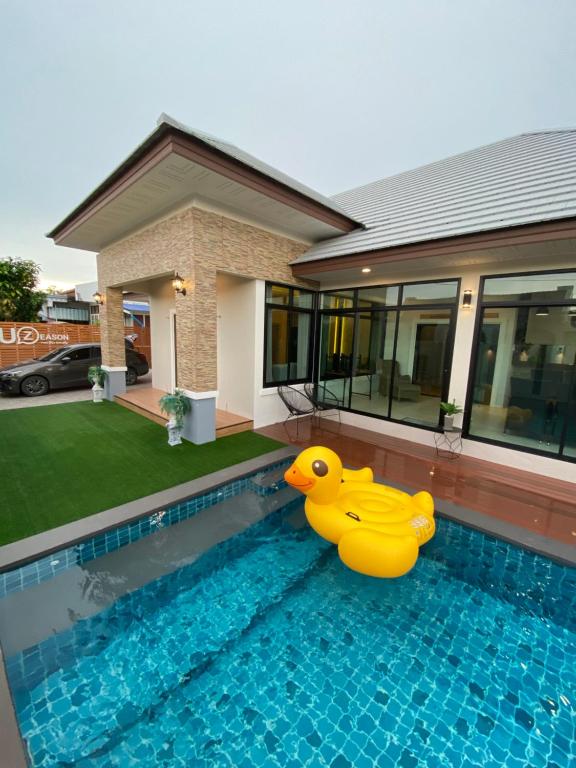 梭桃邑Uzeason Poolvilla Sattahip的坐在游泳池边的大黄橡皮鸭