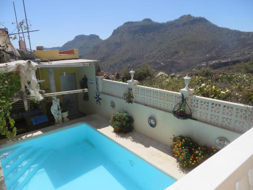 圣巴托洛梅Finca Cortez的一座房子,后面设有游泳池和山脉