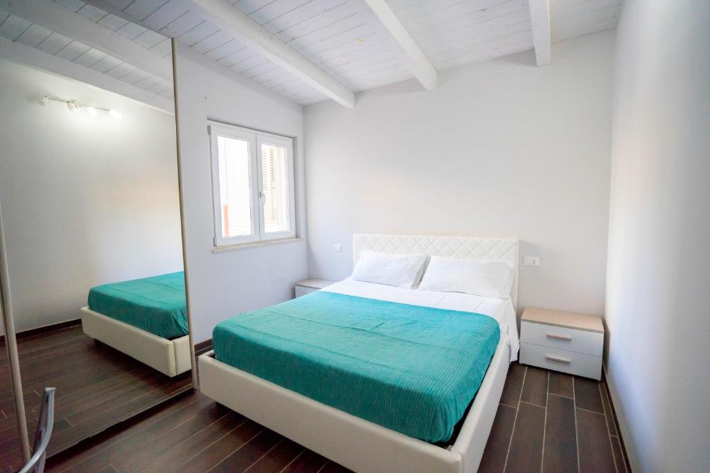卡坦扎罗Garden House的一间卧室配有两张床和镜子
