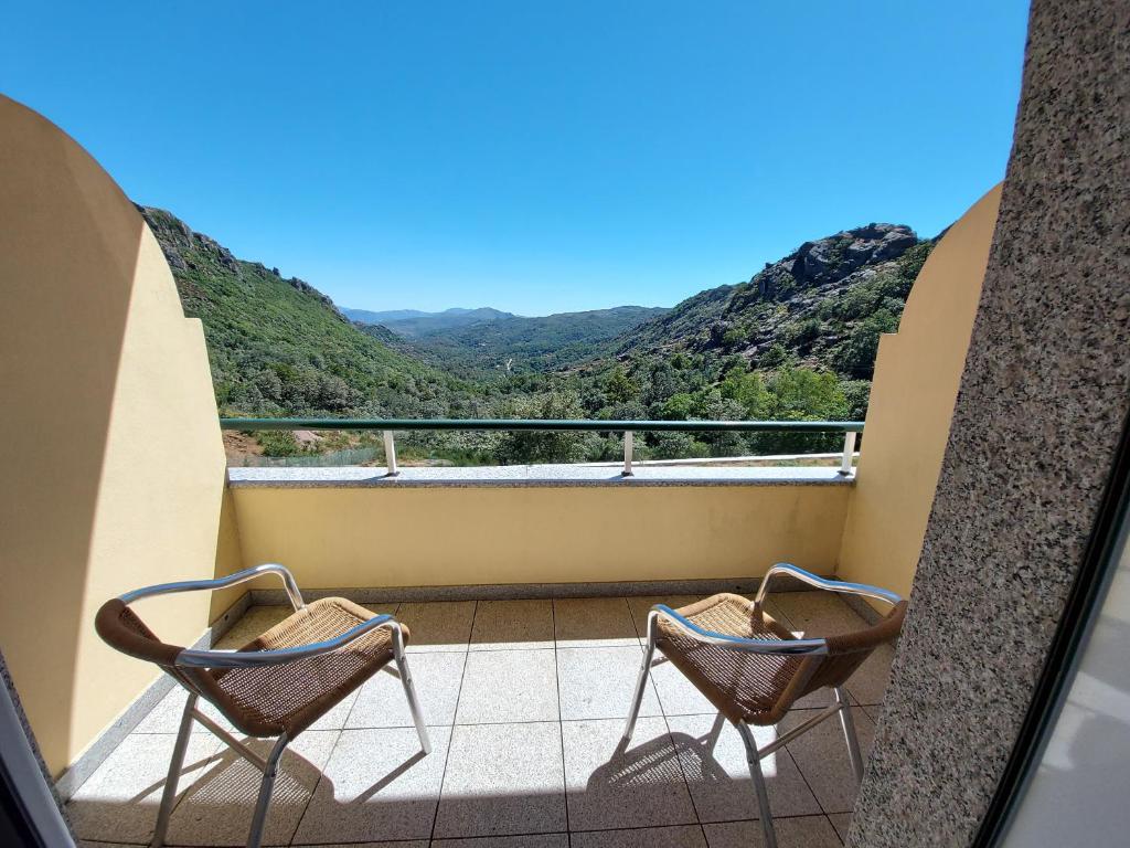 拉博雷鲁堡米拉卡斯特酒店的两把椅子位于一个山景阳台上,后方是
