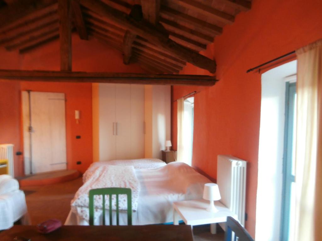 Cella Monte本温努阿尔特洛夫住宿加早餐旅馆的一间卧室设有橙色的墙壁、一张床和一张桌子