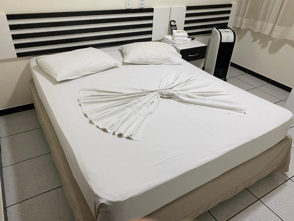 戈亚尼亚Oft Neve's hotel的一张白色的床,上面有弓