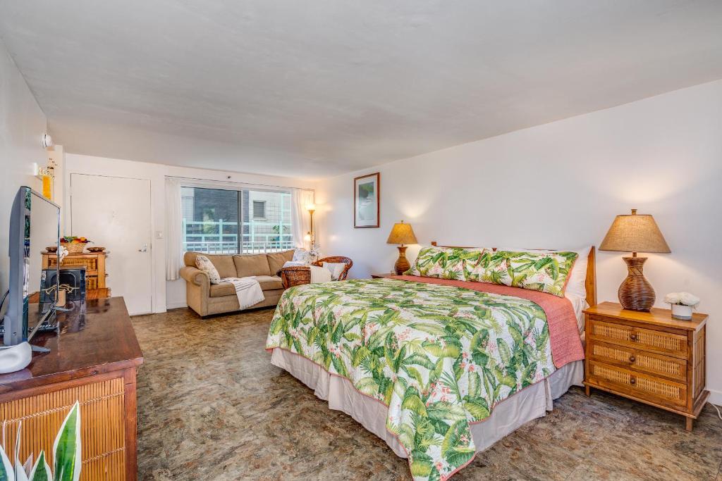 檀香山@ Marbella Lane - Breezy Studio@Diamond Head Beach Hotel的一间卧室设有一张床和一间客厅。