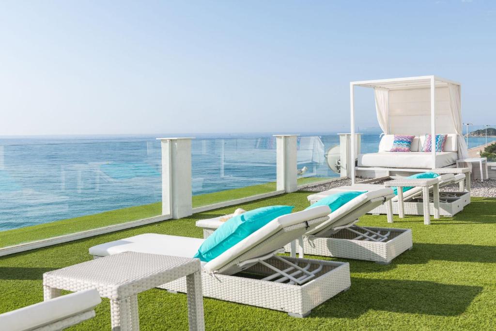 普拉加德阿罗Hotel Planamar by Escampa Hotels的一个带椅子和床的海景阳台