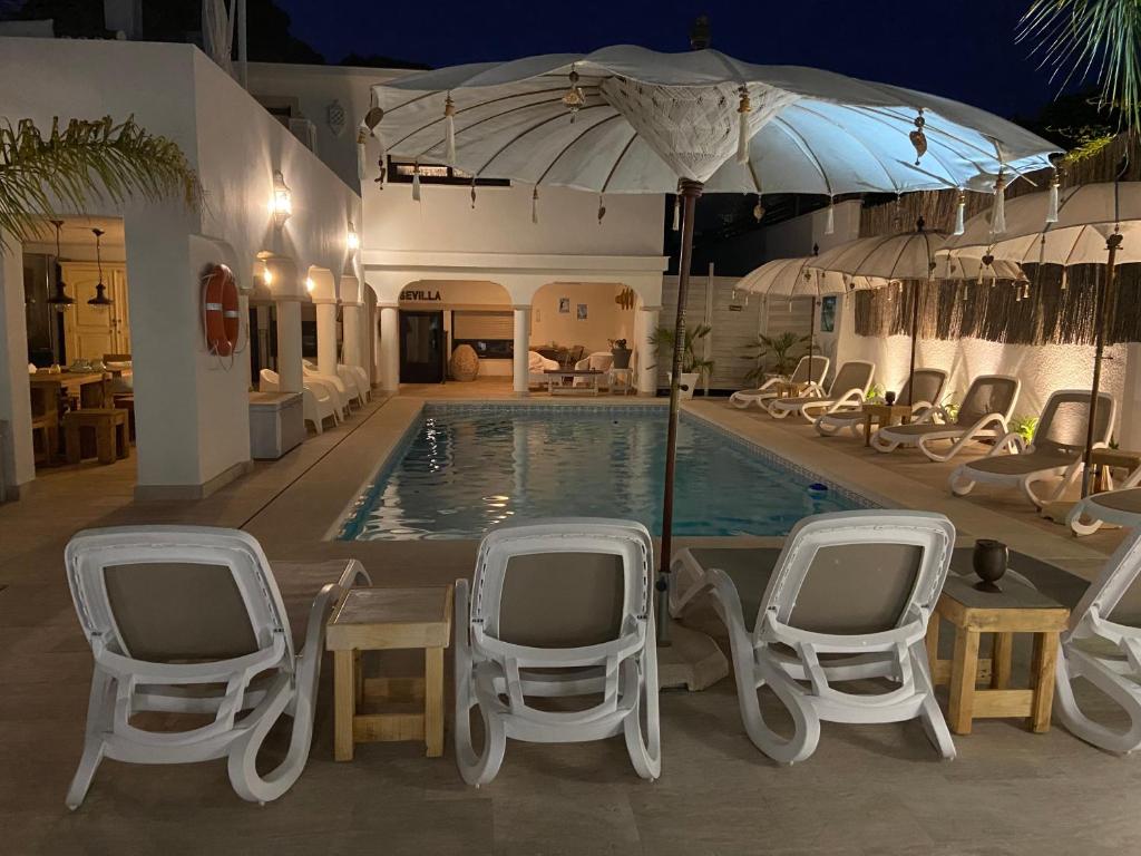 马贝拉Casa Holandaluzas Marbella near Beach, with salt water Pool and private parking的一个带椅子和遮阳伞的游泳池