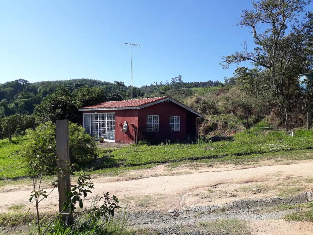 坎皮纳斯Casa de Campo-Linda Vista-SOUSAS的土路旁山丘上的红房子