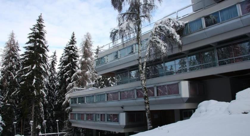 马里尔伊瓦Appartamento Sole Alto的一座被雪覆盖的建筑,前面有树木
