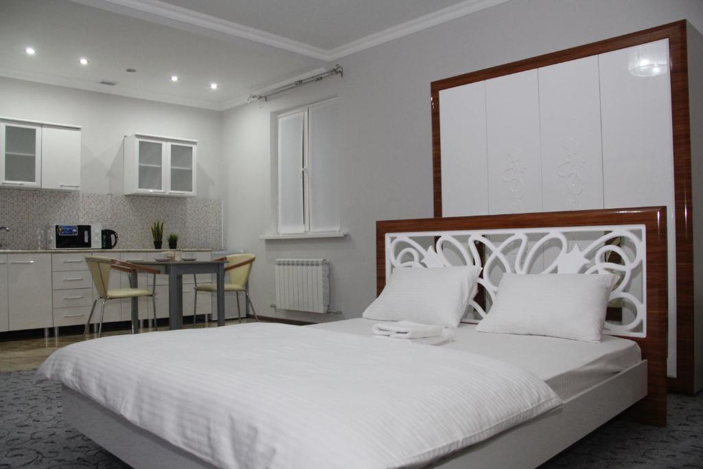 阿特劳萨莱巴图旅馆的一间带白色大床的卧室和一间厨房