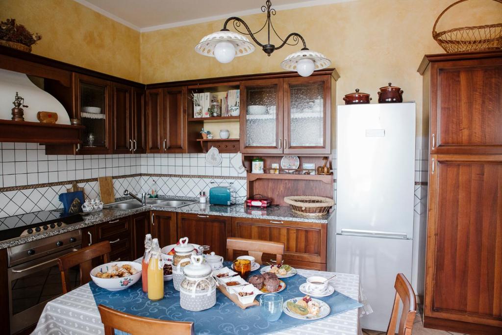 法尔科纳拉·玛里提马la casetta del tesoro的厨房配有桌子和白色冰箱。