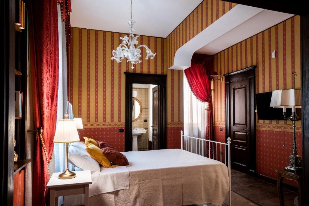 卡利亚里Palazzo Chiara的一间卧室配有一张床和一个吊灯