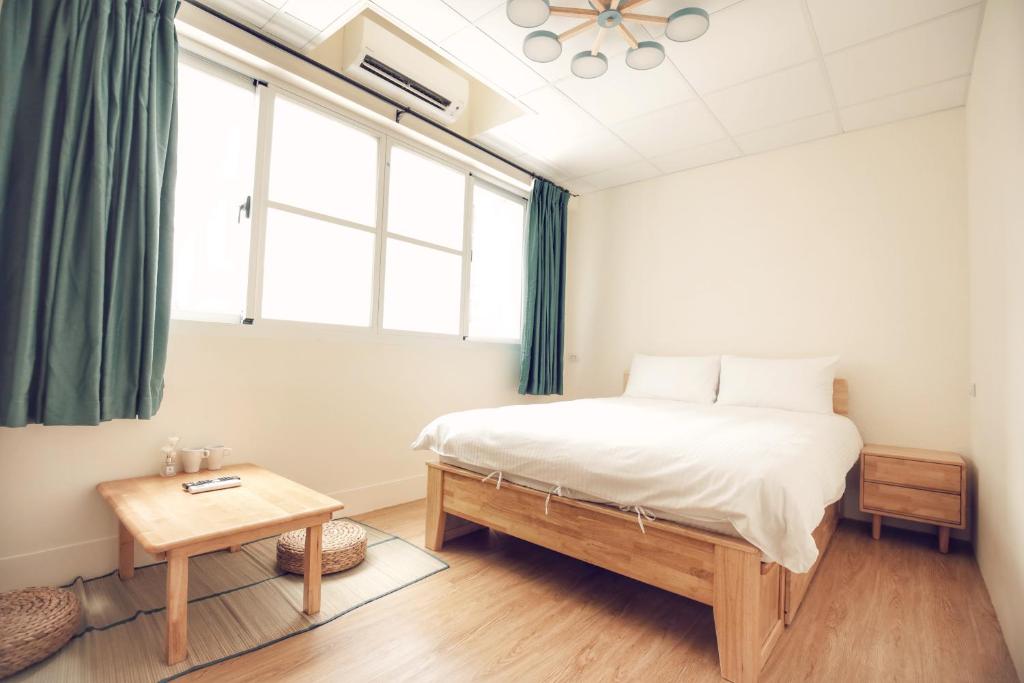台南悦 Ya B&B的一间卧室设有一张床、一个窗口和一张桌子