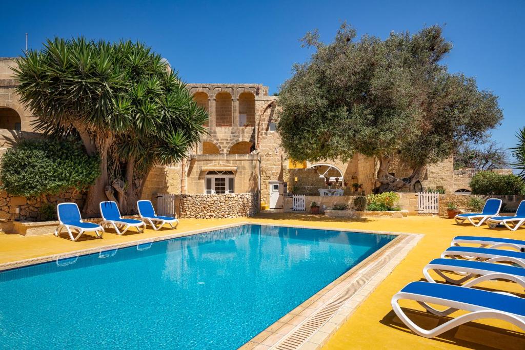 加斯利Razzett Ghasri的一个带躺椅的游泳池以及一座房子