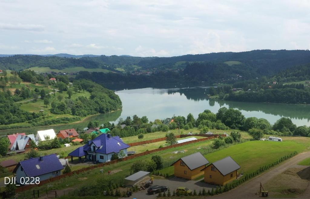 沃乌科维亚Chaty Jak Dawniej的享有湖畔小村庄的空中景色