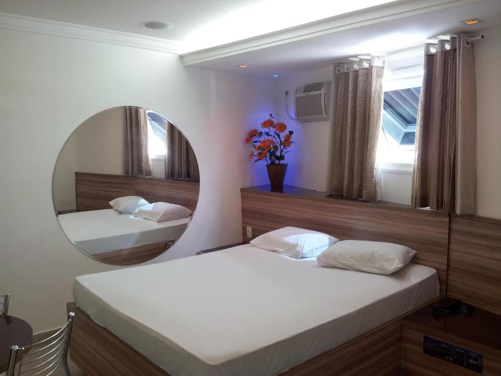 圣保罗盖亚情趣酒店（仅限成人）的一间卧室配有两张床和镜子