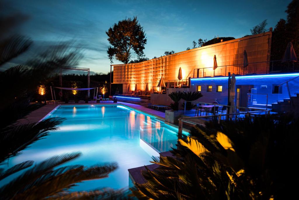 尼阿博勒皮耶韦La Villa的一座游泳池,在晚上在建筑物前