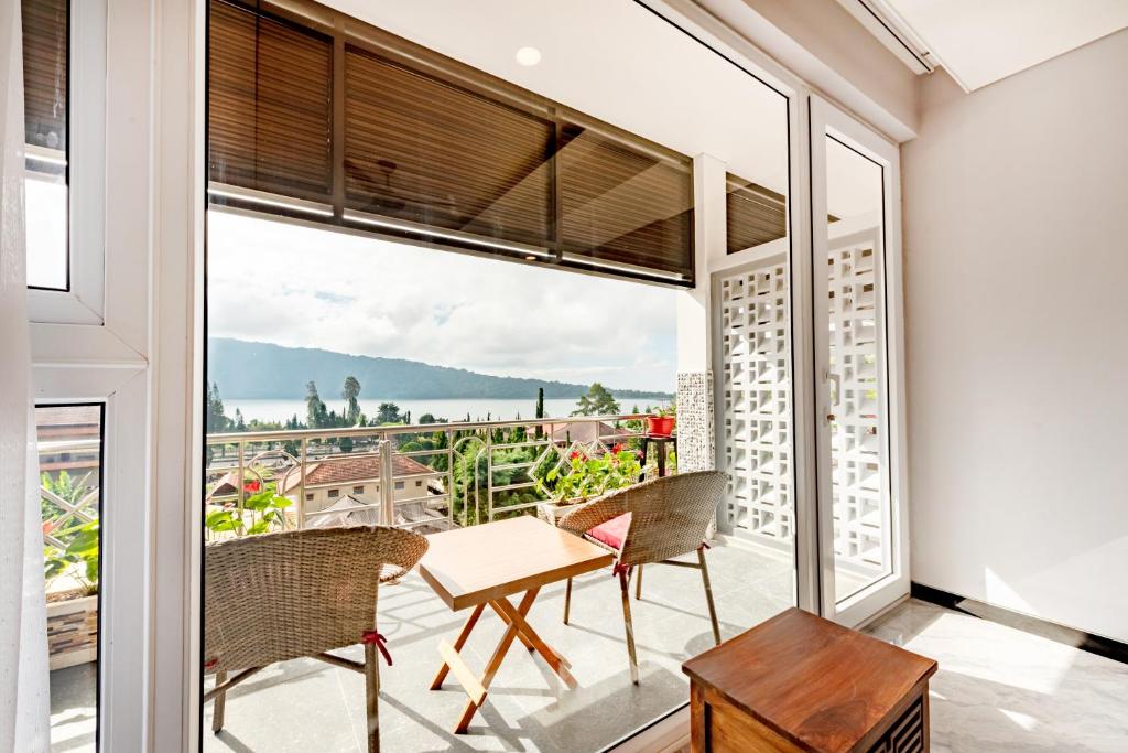 贝都古Dedanau Hotel的客房设有带桌椅的阳台。