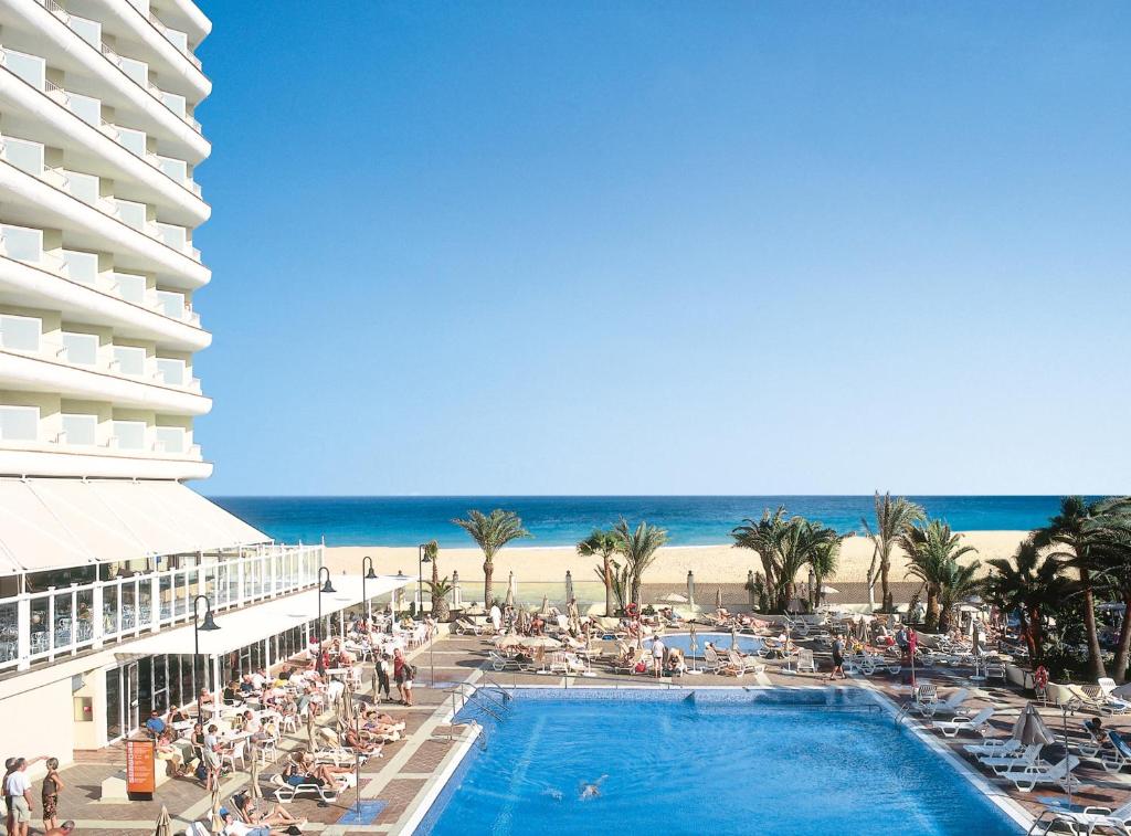 科拉雷侯Hotel Riu Oliva Beach Resort - All Inclusive的海滩旁的游泳池酒店